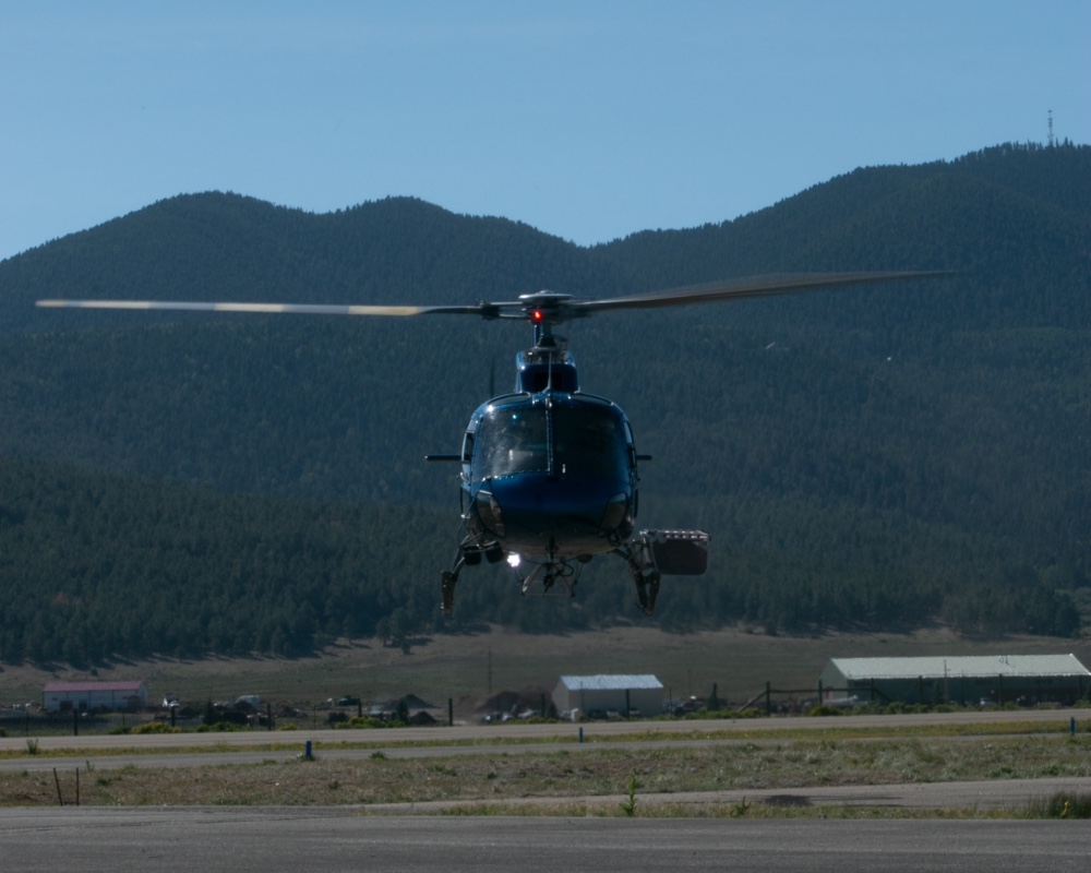 Mountain Air AS350B3 hovering near mountain terrain